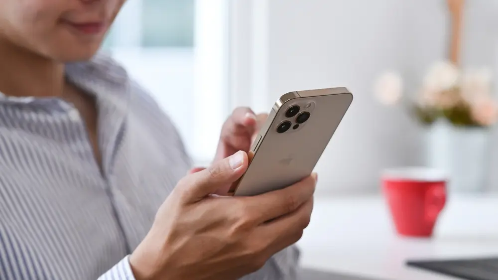 A woman holding an iPhone 12